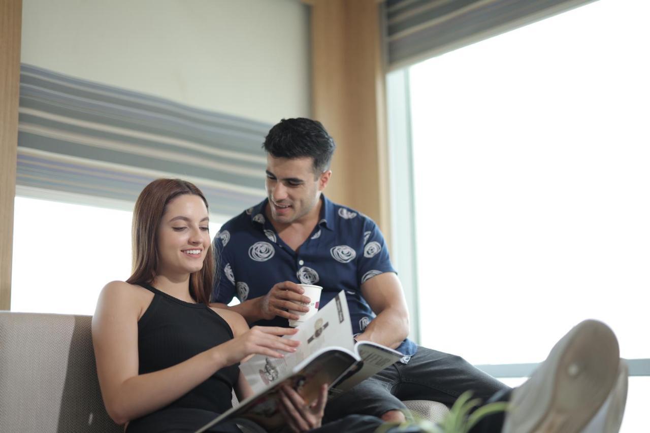 Aloft New Delhi Aerocity Eksteriør bilde A couple reading a magazine